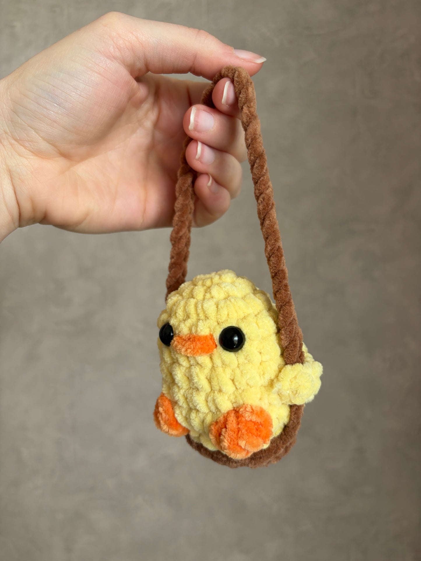 Canard jaune sur sa balançoire