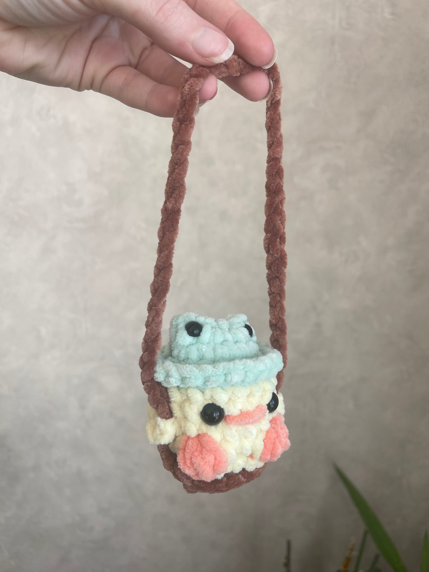 Bébé canard avec chapeau grenouille sur sa balançoire